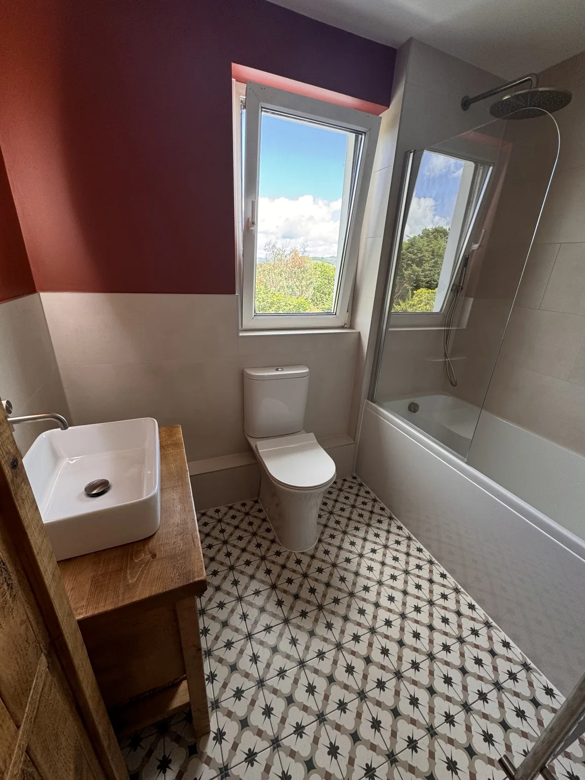 The completed bathroom with bath and overhead shower