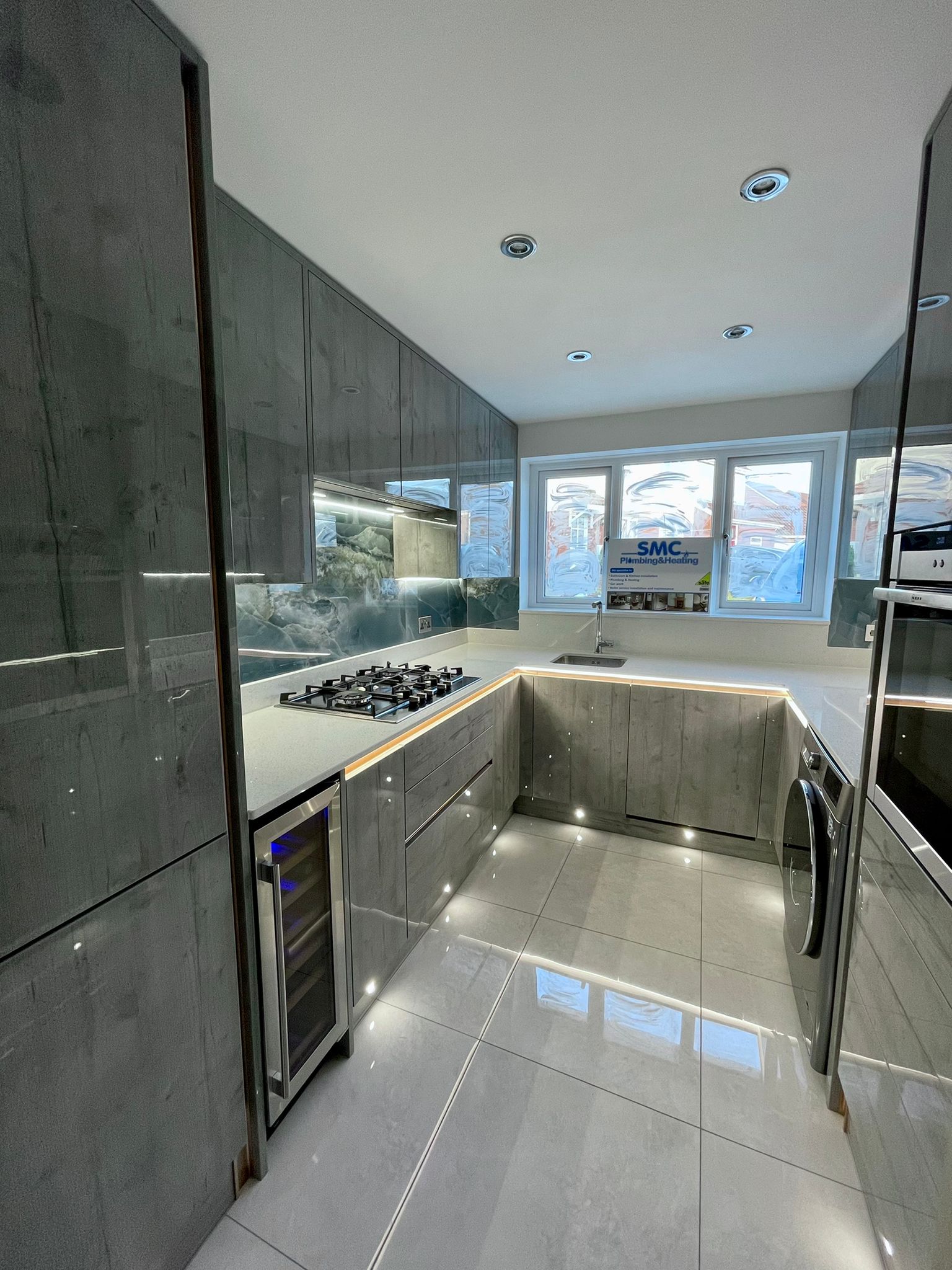 Full-height kitchen cabinets, wine cooler and coordinated lighting
