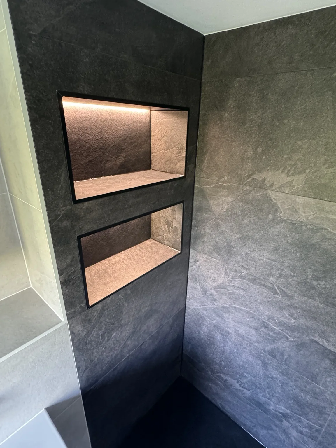 Two LED-lit niches in the darker shower area