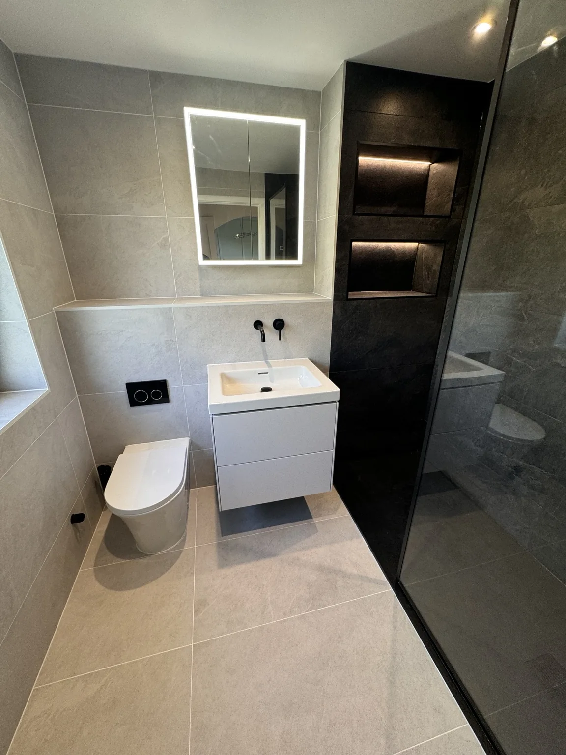 Completed Lisvane en-suite with white Blanco tiles and a darker shower area