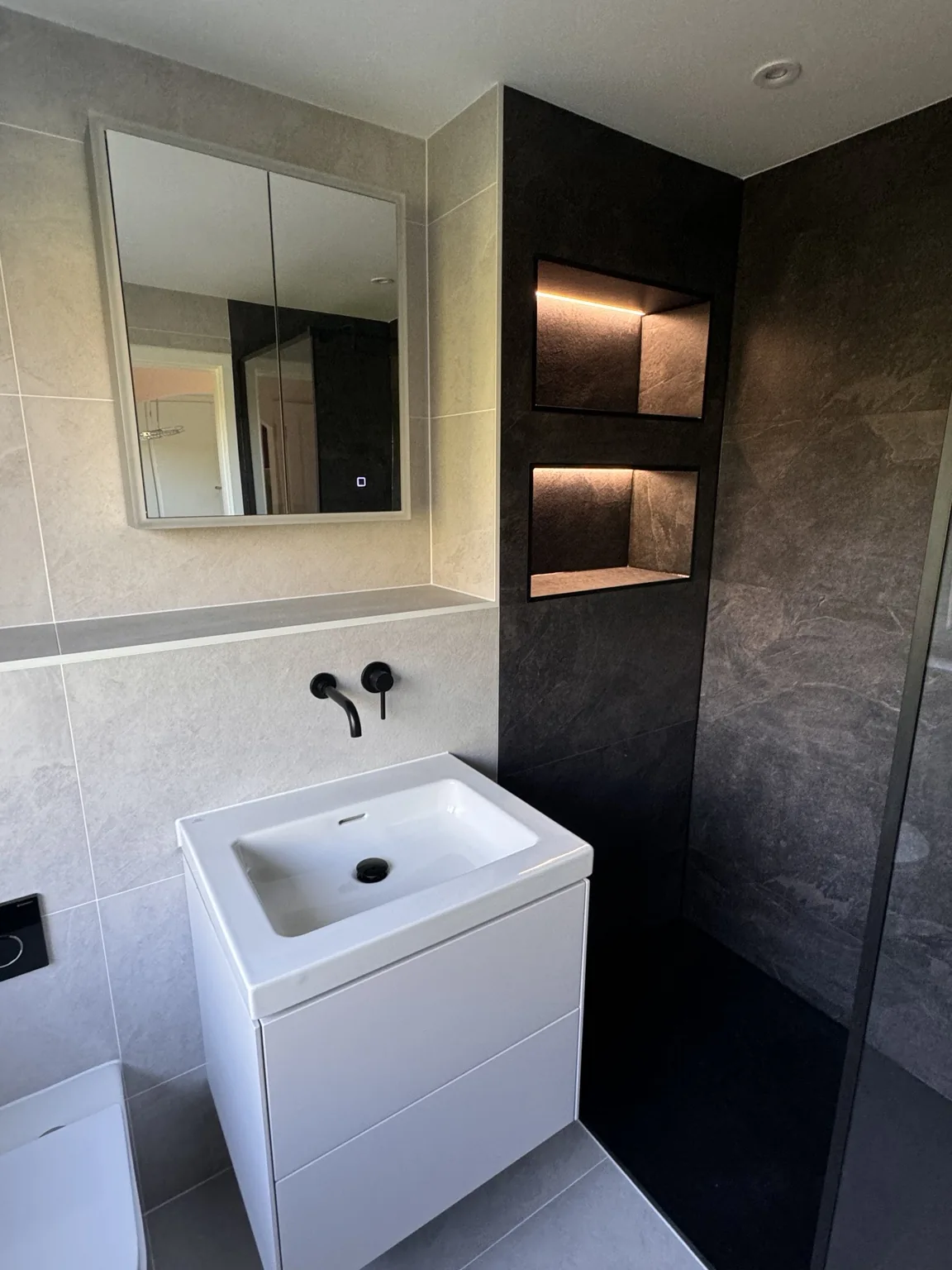 Floating vanity and black wall-mounted basin mixer