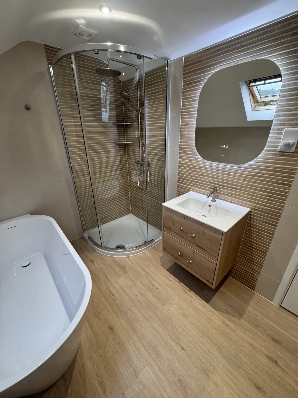 Semi-freestanding bath, quadrant shower and wood-effect vanity in the Rhiwbina loft bathroom