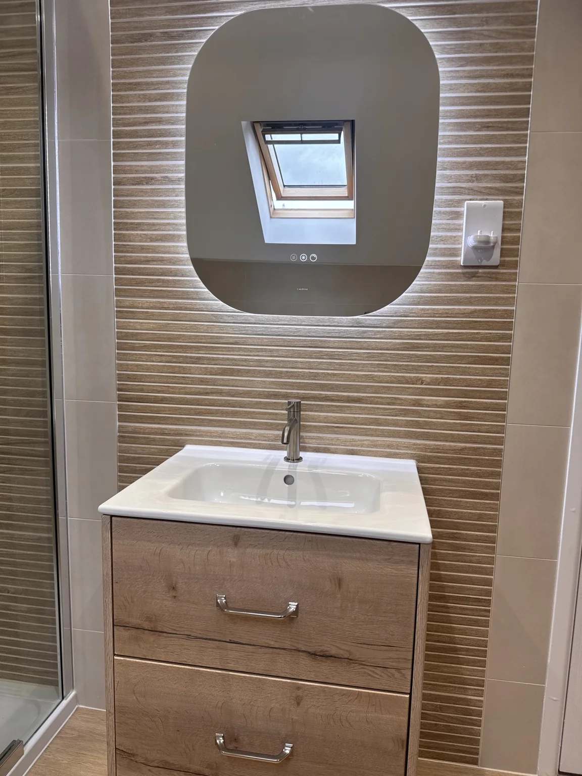Two-drawer wood-effect vanity with white basin and illuminated mirror