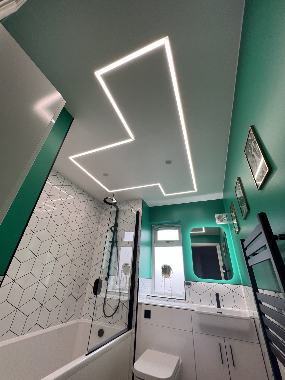 Statement ceiling lighting above the completed teal bathroom